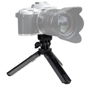 1514886400_349 Godox Mini Tripod AD200 on kompakti musta pöytäjalusta, jossa on kolme kokoontaitettavaa jalkaa ja kiinnityspää kameran turvallista kiinnittämistä varten, kuvassa digitaalikameran tukena valkoista taustaa vasten.