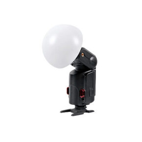 1551345555_026 Godox Witstro Diffusor Ball (ilman metalliosaa), suuri valkoinen diffuusiokupu, on kuvassa kiinnitettynä kameran salamalaitteeseen, jossa on musta runko ja punaiset aksentit, ja joka seisoo tasaisella kiinnitysalustalla valkoista taustaa vasten.