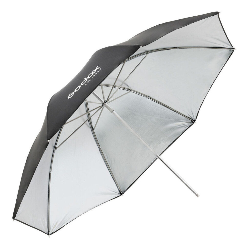 1604592163_135 Godox Silver Umbrella 85cm AD300Pro:lle, jossa on suuri musta-hopea muotoilu metallivarrella ja näkyvällä logolla, on esitetty avattuna valokuvausvalaistusta varten.