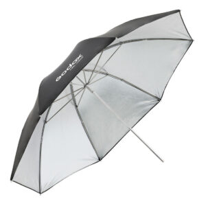 1604592163_135 Godox Silver Umbrella 85cm AD300Pro:lle, jossa on suuri musta-hopea muotoilu metallivarrella ja näkyvällä logolla, on esitetty avattuna valokuvausvalaistusta varten.