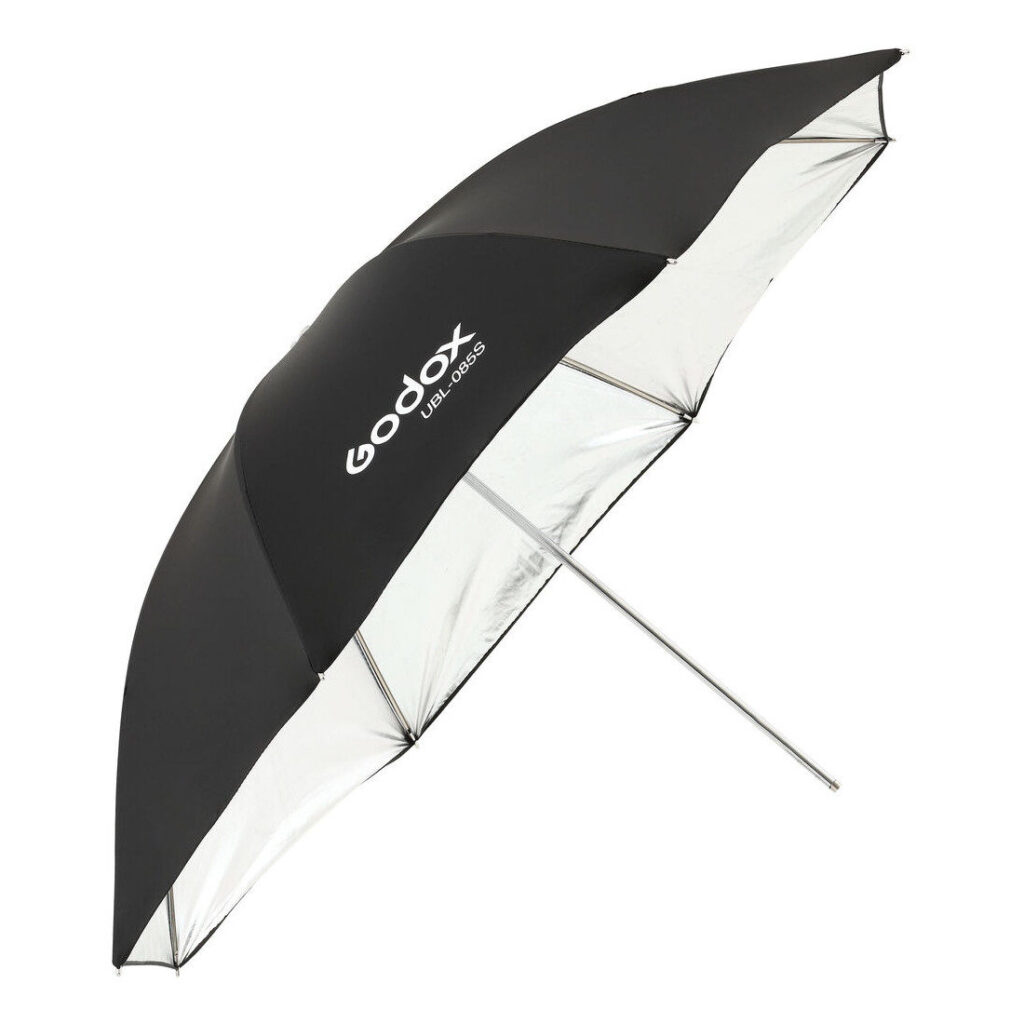 1604592165_247 Godox Silver Umbrella 85cm for AD300Pro on mustavalkoinen studiovalovarjo, jossa on heijastava hopeinen sisäpuoli, metallinen varsi ja Godoxin logo valkoisella mustalla ulkopinnalla.