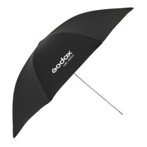 1605010703_813 Musta Godoxin valkoinen sateenvarjo 85cm AD300Pro:lle, jossa on valkoinen teksti "Godox UBL-085W" yhdessä paneelissa, kuvattu vinossa hopeisella varrella.