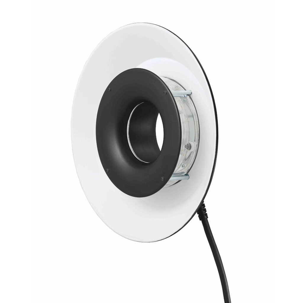 1608637495_549 Godox RFT-21 Rengassalamaheijastin R1200 White -valaisimelle sisältää pyöreän LED-rengasvalon, jossa on valkoinen ulkokehä ja musta keskikehä ja joka on asennettu kirkkaaseen kiinnikkeeseen, jossa on virtajohto, kuvassa valkoista taustaa vasten.