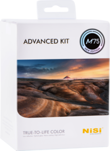 Valkoinen vähittäismyyntipakkaus, jossa on merkintä NiSi M75 Advanced Kit 75mm System ja jonka etupuolella on maisemakuva kallioisesta maastosta ja kaukaisesta vuoresta värikkään taivaan alla.