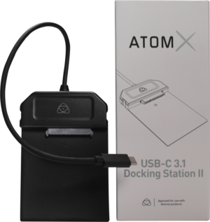 800q-01_121993 Musta ATOMOS AtomX USB-C 3.1 Powered Docking Station -telakointiasema, johon on liitetty kaapeli, näkyy pakkauksen vieressä, jossa on tuotemerkki ja kuva.