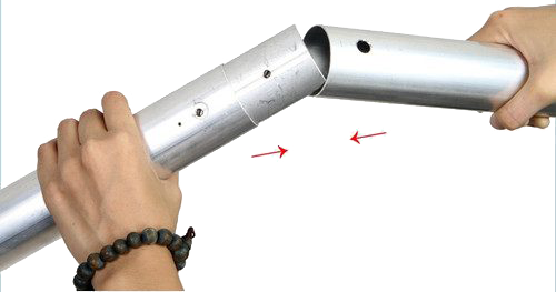800q-02_122084 Two hands connect two NANLITE Background Tube 3 metre tubes; one tube is inserted into the other, and the red arrows highlight the point of connection.