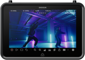 ATOMOS SHOGUN 7-tuumainen HDR-monitori-tallennin 6K RAW näyttää kaksi tanssijaa teollisuusmaisemassa, jossa siniset ja violetit neonvalot, pilarit ja kameran asetukset näkyvät näytön yläreunassa.