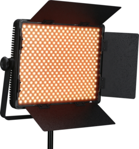 800q-03_116384 NANLITE 900CSA Bicolor LED-paneeli, jossa on neljä säädettävää mustaa lato-ovea ja joka on asennettu jalustalle, näytetään kytkettynä päälle ja heittää lämmintä oranssia hehkua.