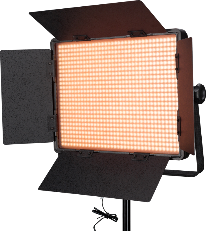 NANLITE 900DSA 5600K LED-paneeli DMX-ohjauksella on suorakulmainen LED-studiovalo, jossa on avoimet lato-ovet ja joka säteilee lämmintä oranssia hehkua. Se on asennettu mustaan jalustaan, jonka alla roikkuu virtajohto.