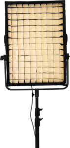 800q-03_116546 NANLITE Eggcrate for Compac 200/200B, musta ristikkohajottaja, näkyy asennettuna studio-LED-valaisimeen, jossa on pehmeä lämmin hehku ja joka on sijoitettu säädettävälle mustalle jalustalle tavallista taustaa vasten.