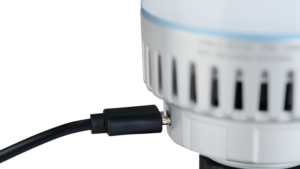800q-04_118876 Lähikuva NANLITE USB-C to DMX Cable Splitter -kaapelinjakajasta, joka on kytketty pyöreään, valkoiseen laitteeseen, jossa on sivussa tuuletusrakoja tavallista taustaa vasten.