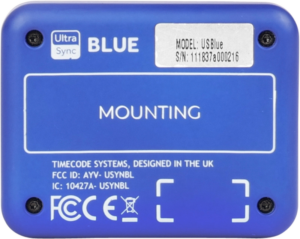 800q-05_121975 ATOMOS Ultrasync Blue on sininen laite, jonka takapuolelle on painettu asennusohjeet, säädöstiedot, malli- ja sarjanumerot sekä FCC-tunnus. Timecode Systems on suunnitellut sen Yhdistyneessä kuningaskunnassa.