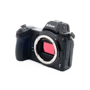 Nikon Z6 3260-4 Nikon Z6 (SC 3500) - Käytetty peilitön kamerarunko on kuvassa mustana, ja se on käännetty niin, että objektiivin kiinnitys, kenno ja ohjauspainikkeet kahvassa ja yläosassa tulevat esiin.