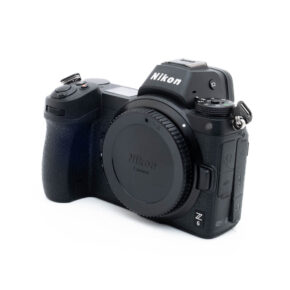 Nikon Z6 3260-5 Käytetty Nikon Z6 (SC 3500) -kamerarunko, musta, kuvattu edestä vasemmalta ilman objektiivia valkoista taustaa vasten.