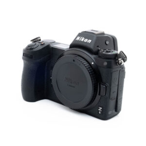 Nikon Z6 3260-5 Käytetty Nikon Z6 (SC 3500) -kamerarunko, musta, kuvattu edestä vasemmalta ilman objektiivia valkoista taustaa vasten.