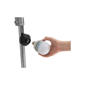 nane27mag2 Käsi pitää valkoista LED-lamppua lähellä metallista pylvästä, jossa on musta NANLITE E27 -magneettisovitin, ja näyttää asentavan tai irrottavan lamppua.