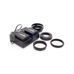 x100v_tarvikkeet-1 Fujifilm X100V tarvikepaketti - Käytetty, jossa on akkulaturi, jossa on kaksi akkua, USB-kaapeli ja neljä mustaa pyöreää linssisuodatinadapteria, näkyy valkoisella pohjalla.