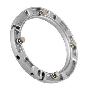 1399277883_062 Godox Softbox Universal Adapter on hopeinen metallinen pyöreä kiinnitysrengas, jossa on kolme tasaisin välimatkoin olevaa pulttia, kuvassa vinossa valkoisella pohjalla.