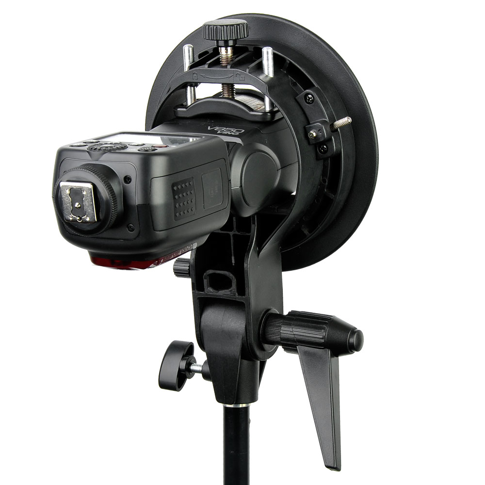1448260748_222 Godoxin S-kiinnike Elinchrom Rotolux 80x80cm softboxilla ja ritilällä on asennettu jalustalle, jossa on säätönupit, kuvassa valkoista taustaa vasten.