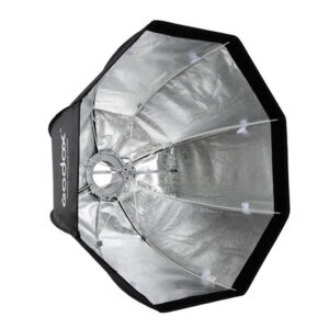1535118728_039 The Godox SB-GUE120 Umbrella Softbox Bowens 120cm with Grid is a silver-coloured reflective light converter with black edges for photography, presented open and angled to reveal its internal structure and metallic surface.