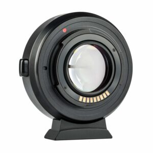1547044526_175 Lähikuva mustasta Viltrox EF-FX2 Autofocus Adapter 0,71x -objektiivista, jossa on lasielementti, elektroniset koskettimet ja punainen kohdistuspiste, joka on pystyssä pienellä alustalla valkoista taustaa vasten.