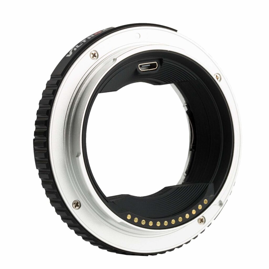 1547044583_434 Viltrox EF - GFX II Autofocus Adapterin lähikuvassa sen metallisesta ja mustasta renkaasta paljastuvat elektroniset koskettimet ja USB-portti, jotka mahdollistavat automaattitarkennuksen yhteensopivuuden EF-mount-objektiivien ja Fujifilm GFX -kamerarunkojen välillä.