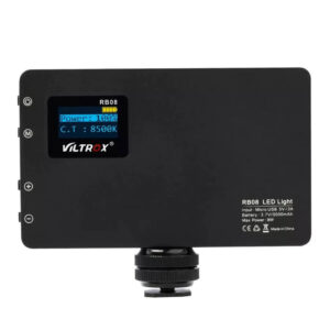 1562766643_329 Musta Viltrox RB08 LED-valo, jossa on pieni näyttö, näyttää tehon 100 %:ssa ja värilämpötilan 8500K. Ohjauspainikkeet ovat vasemmalla, ja kiinnitystarvikkeet on kiinnitetty pohjaan.