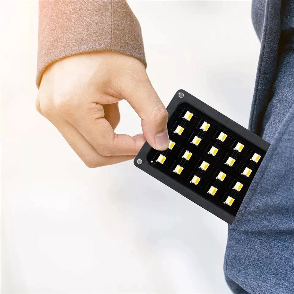1562766646_375 Käsi laittaa pienikokoisen Viltrox RB08 LED-valon, jossa on useita lamppuja, sinisten housujen taskuun.
