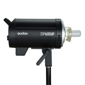 1582637389_163 Musta Godox DP600III -studiostrobovalo on asennettu valotelineeseen, ja se näkyy sivulta valkoista taustaa vasten. Laitteessa on näkyvä lamppu ja sen rungossa on sen tuotemerkin etiketti.
