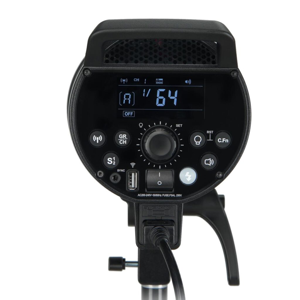 1594299270_156 Lähikuva Godox DP800III -studiostrobotin takapaneelista, jossa on digitaalinäyttö "64", useita painikkeita, valitsimia ja portteja asetusten säätöä varten, kaikki asennettuna jalustalle.