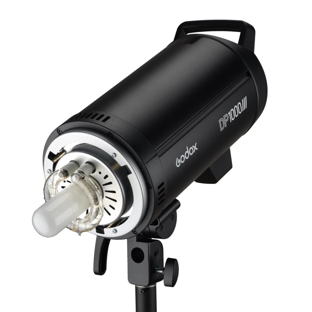 1594299372_040 Godox DP1000III musta studiostrobovalo, jossa on näkyvä salamaputki ja mallinnuslamppu, on asennettu valotelineeseen valkoista taustaa vasten.