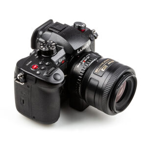 1596459163_070 Valkoisella taustalla näkyy musta Panasonic Lumix GH5 -kamera, jossa on erilaisia painikkeita ja valitsimia ja joka on varustettu Viltrox Nikon F-M1 -objektiivin kiinnityssovittimella.