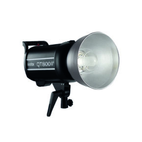 1603097346_689 A black Godox QT800II M studio flash, fitted with a silver reflector and mounted on an adjustable bracket, is shown against a white background.