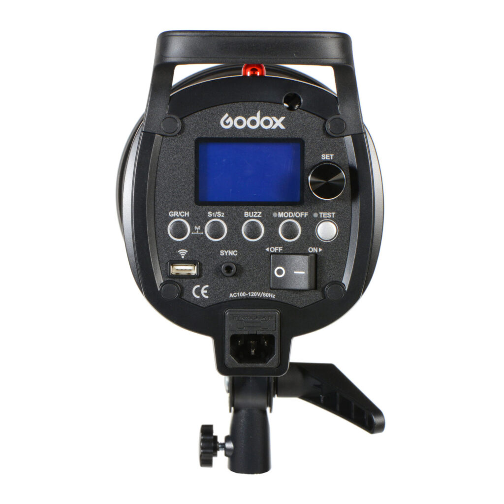 1603173357_219 Godox QS800II -studiostroboskooppivalaisimen takanäkymä, jossa on digitaalinen näyttö, pyöreät ohjauspainikkeet, portit ja kiinnitysteline valkoista taustaa vasten.
