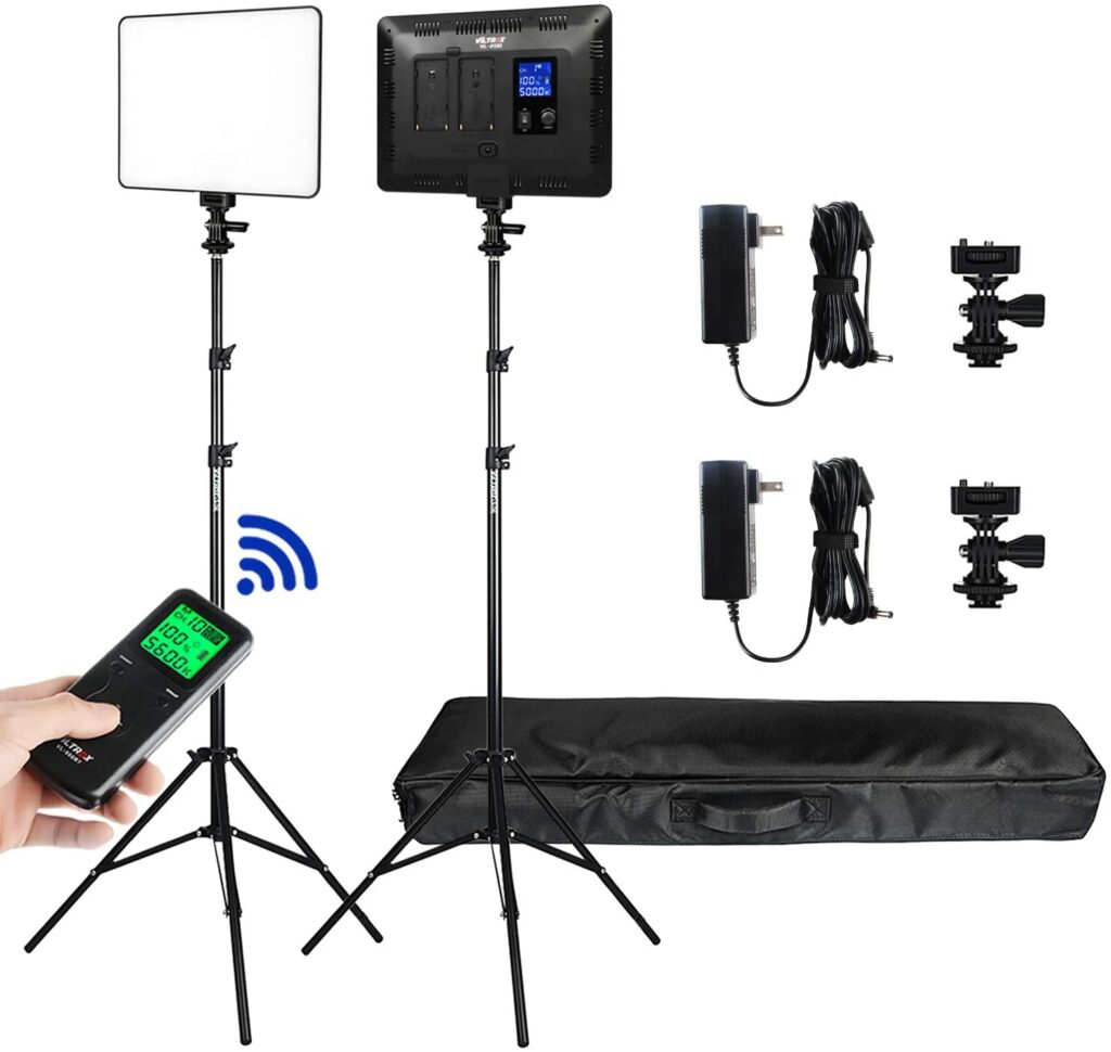 1606232542_987 The Viltrox VL 200T LED Light Duo Kit, pictured in white, includes two LED panel lights with adjustable stands, a remote control with green display, two power adapters, two mounting brackets, cables and a black carrying case.