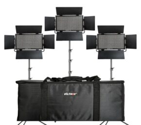 1608192336_717 Kolme Viltrox VL D60T LED-paneelivalaisinta, joissa on säädettävät lato-ovet, on asennettu jalustalle suuren mustan kantolaukun taakse. Nämä valot ja kotelo muodostavat Viltrox VL D60T LED-valojen kolmoissarjan.