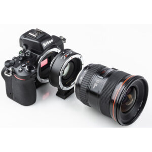 1630327968_418 Nikon-kameran runko on liitetty Viltrox EF - Z2 Speed Boosteriin, joka on kiinnitetty suureen kameran objektiiviin, kaikki valkoisella taustalla.