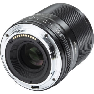 Lähikuva Viltrox AF 33mm f/1.4 -objektiivi, Nikon Z -objektiivista, jossa korostuvat sen metallinen kiinnitys, elektroniset koskettimet, objektiivilasi ja tarkennusetäisyysmerkinnät tynnyrissä.