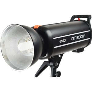 1637154278_243 Musta Godox QT1200II M -studiostroboskooppivalaisin, jossa on hopeinen heijastin ja joka on asennettu pieneen säädettävään kiinnikkeeseen. Siinä on sivukahva ja näkyvä Godoxin tuotemerkki.