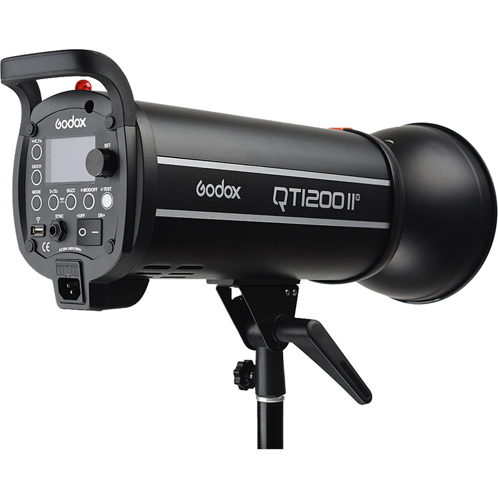 1637154279_264 Musta Godox QT1200II M -studiostroboskooppivalaisin on asennettu valotelineeseen, ja sen ohjauspaneelissa on useita painikkeita, kytkimiä, portteja ja virtajohdon liitäntä.