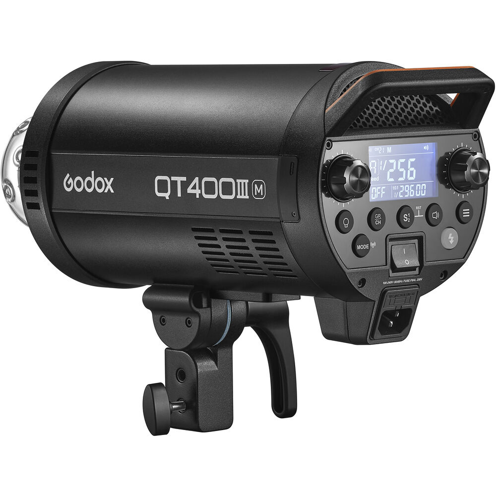 1643029787_938 Musta Godox QT400IIIM-stroboskooppivalaisin, jossa on digitaalinen näyttö, ohjauspainikkeet ja kiinnitysteline, pienestä kulmasta katsottuna.