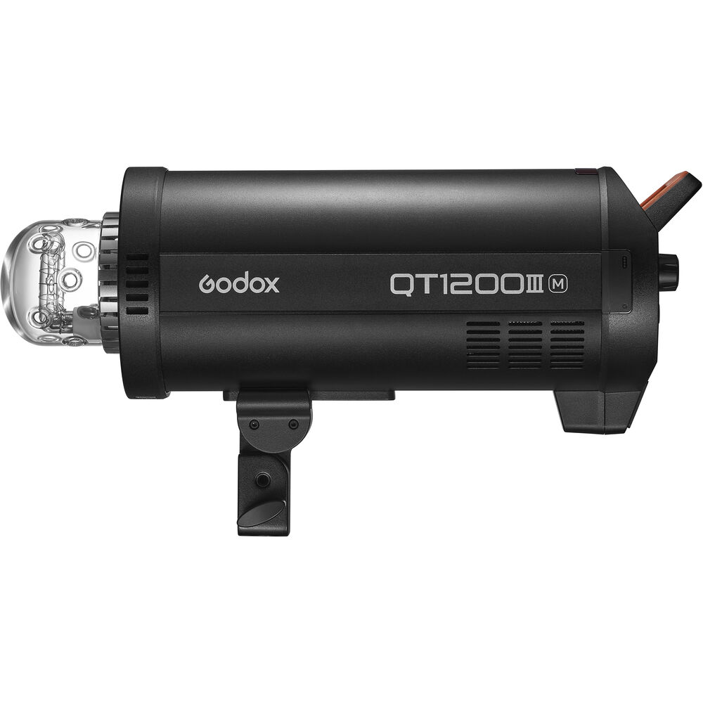 1643029963_377 Musta Godox QT1200IIIM -studiostroboskooppivalaisin näkyy sivuprofiilissa, ja sen läpinäkyvä lamppukotelo korostuu etu- ja takapuolen ohjauspainikkeissa.