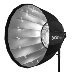1646908028_424 Godox Parabolic Softbox Bowens Mount P120H mustaa ja hopeaa, jossa on heijastava sisäpinta ja kahdeksankulmainen muoto on asennettu jalustalle, ihanteellinen valon hajottamiseen valokuvauksessa ja videokuvauksessa.
