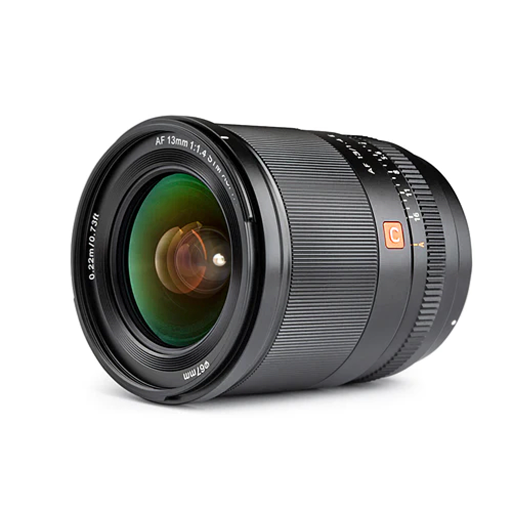 Sony E:lle tarkoitetun Viltrox AF 13mm f/1.4 -objektiivin lähikuvassa näkyy musta objektiivi, jossa on kuvioidut tarkennus- ja zoomausrenkaat, vihreät heijastukset lasissa ja valkoiset merkinnät 13 mm:n polttoväli- ja f/1.4-16-aukkoasetuksille.