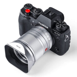 1673430169_093 Mustaa Fujifilm X-T2 -digitaalikameraa näytetään ylhäältä päin kulmasta, ja siinä on erilaisia valintakiekkoja ja painikkeita, ja sen objektiiviin on kiinnitetty suuri Viltrox 23/33/56 mm:n metallinen nelikulmainen huppu (hopea).