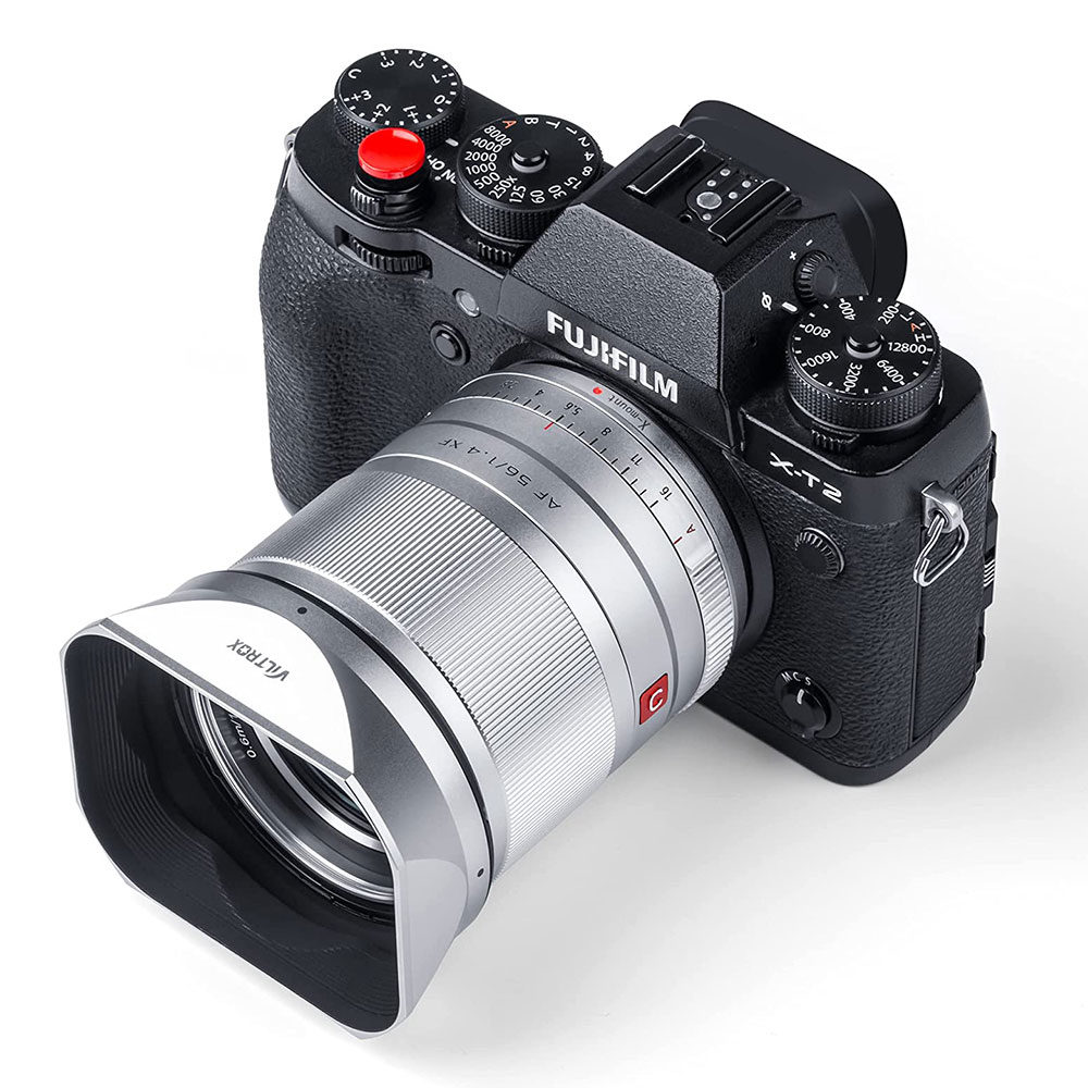 1673430169_093 Mustaa Fujifilm X-T2 -digitaalikameraa näytetään ylhäältä päin kulmasta, ja siinä on erilaisia valintakiekkoja ja painikkeita, ja sen objektiiviin on kiinnitetty suuri Viltrox 23/33/56 mm:n metallinen nelikulmainen huppu (hopea).