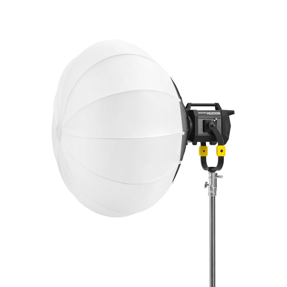 1678969401_435 Godox GL4 Lantern Softbox 120cm, joka on suunniteltu KNOWLED MG1200Bi LED-valaisimelle, on varustettu suurella pyöreällä valkoisella diffuusorilla, ja se on asennettu korkeaan metallijalustaan valkoista taustaa vasten.