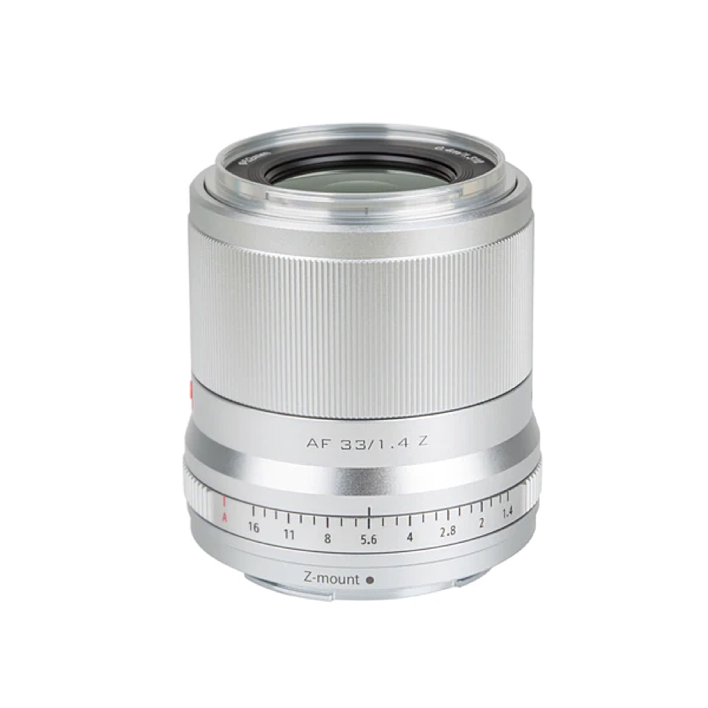 1680074092_028 Viltrox AF 33mm f/1.4 -objektiivi Nikon Z:lle, kuvassa hopeanvärinen, jossa on uurrettu tarkennusrengas ja aukkoasteikko (f/1.4-f/16), on kuvattu valkoista taustaa vasten.