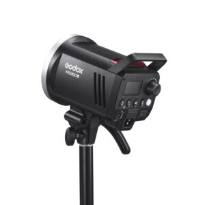 1682431400_697 The black Godox MS300V studio strobe is mounted on a stand, and has a control panel on the back with dials, buttons and ports.