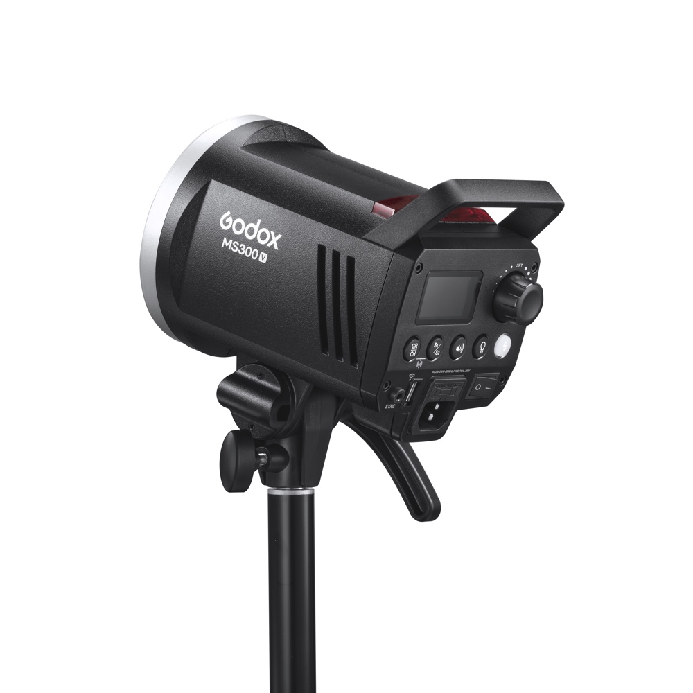 1682431400_697 The black Godox MS300V studio strobe is mounted on a stand, and has a control panel on the back with dials, buttons and ports.